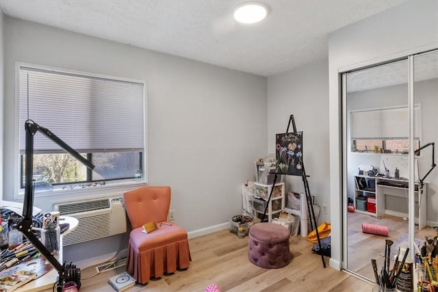 living area featuring light hardwood / wood-style flooring and a textured ceiling