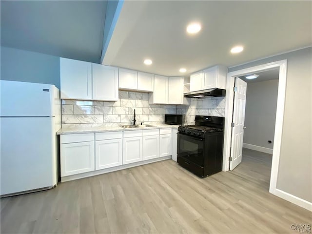 kitchen with sink, backsplash, black appliances, white cabinets, and light wood-type flooring