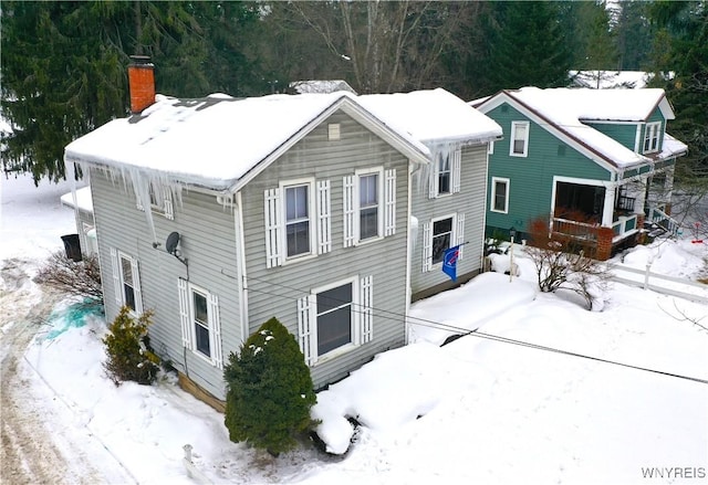 view of snow covered back of property