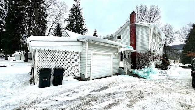 view of snow covered exterior with a garage