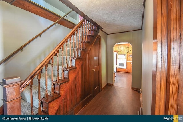 staircase with a textured ceiling