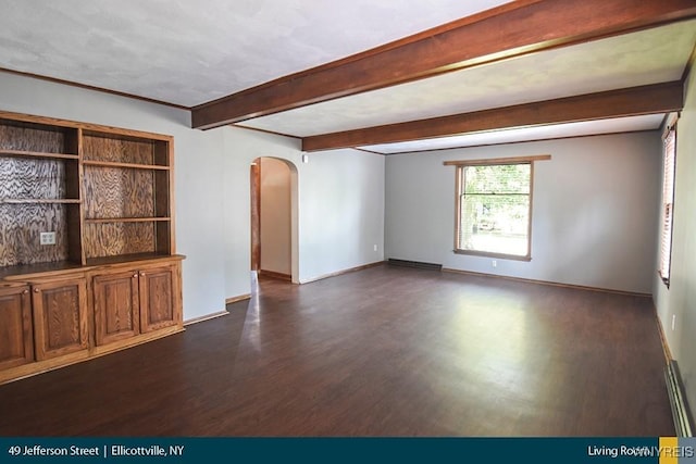 empty room with arched walkways, beam ceiling, dark wood finished floors, and baseboards