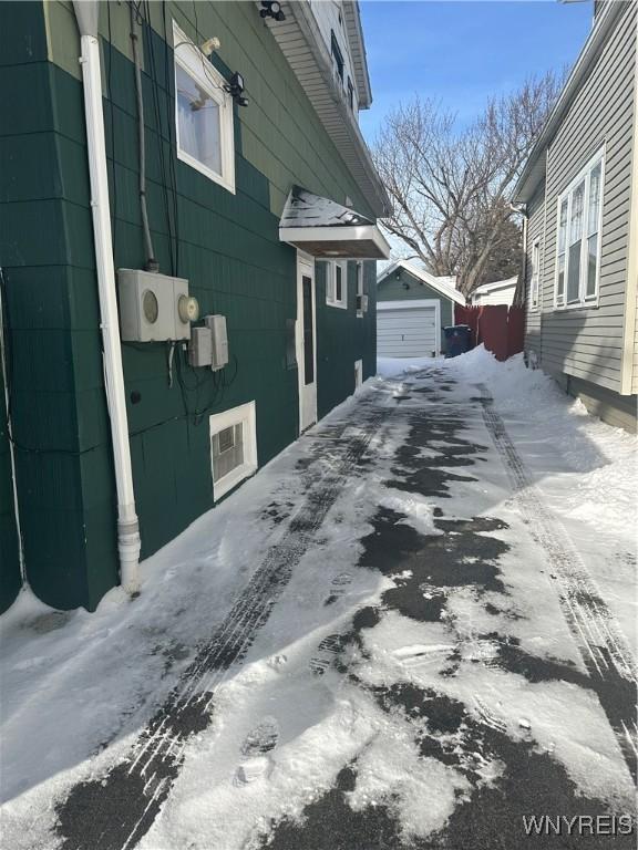 snow covered property with an outbuilding and a garage