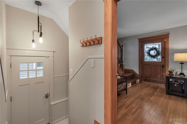 entrance foyer with wood-type flooring and vaulted ceiling