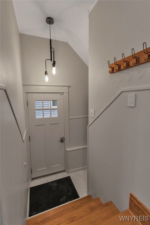 tiled foyer entrance featuring vaulted ceiling