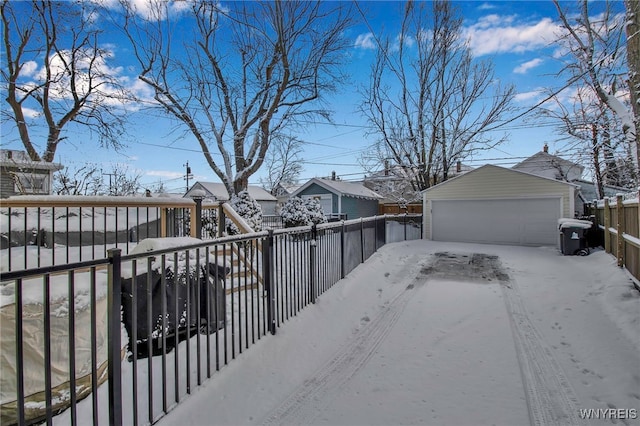 yard covered in snow featuring an outbuilding and a garage