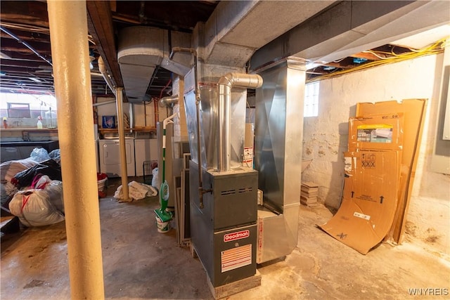 utility room featuring heating unit and washing machine and clothes dryer