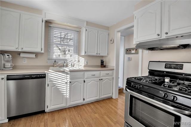 kitchen featuring white cabinetry, sink, stainless steel appliances, and light wood-type flooring