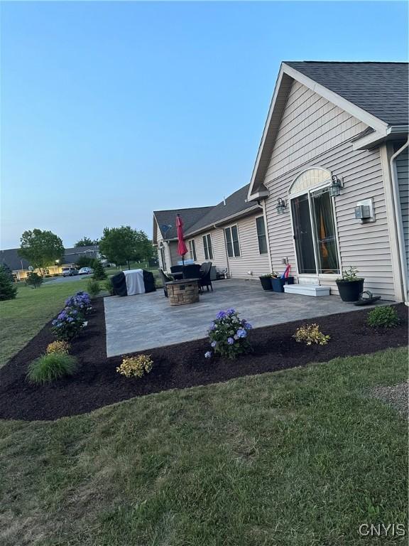 rear view of property featuring a patio area and a lawn