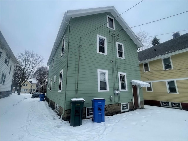 view of snow covered back of property