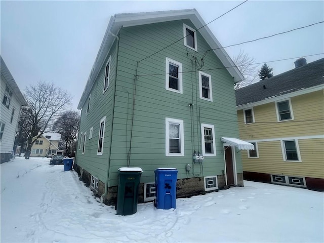 view of snow covered rear of property