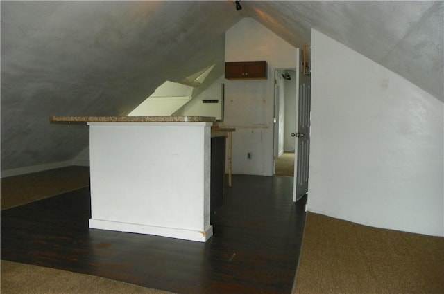 additional living space featuring lofted ceiling and dark wood-type flooring