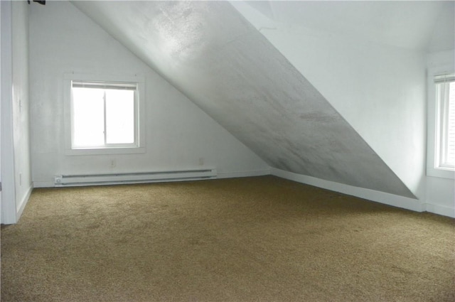 additional living space featuring baseboard heating, vaulted ceiling, and carpet