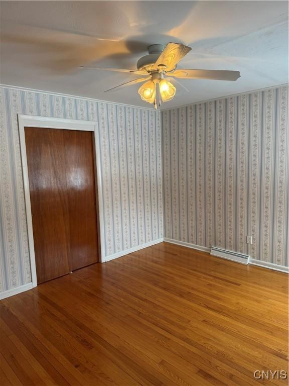 unfurnished bedroom featuring wood-type flooring, ceiling fan, and a closet