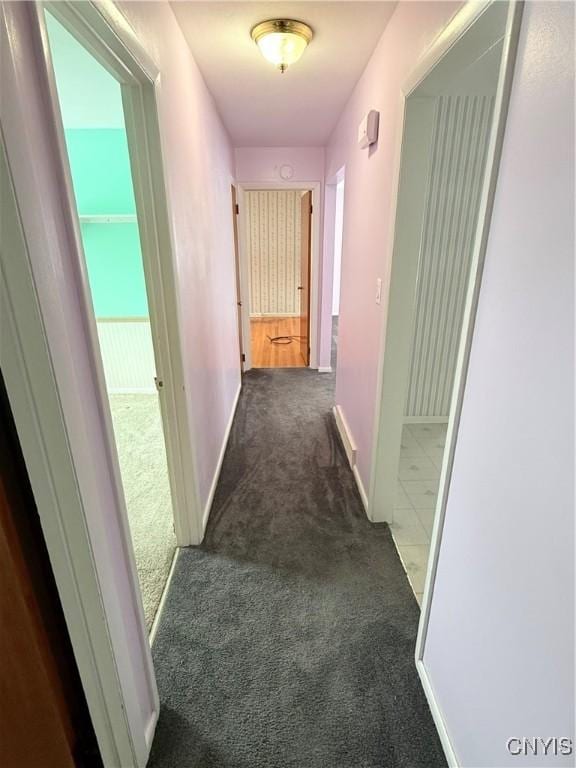 hall featuring dark carpet