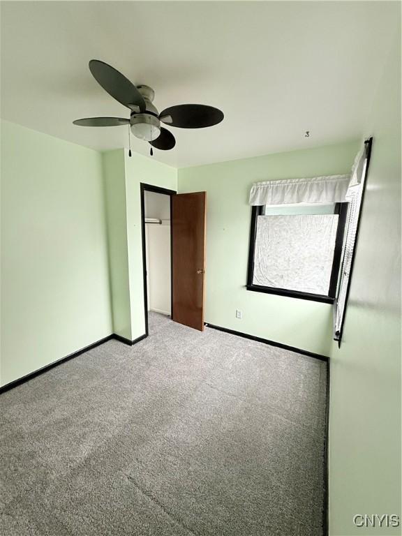 unfurnished bedroom with ceiling fan, a closet, and light carpet