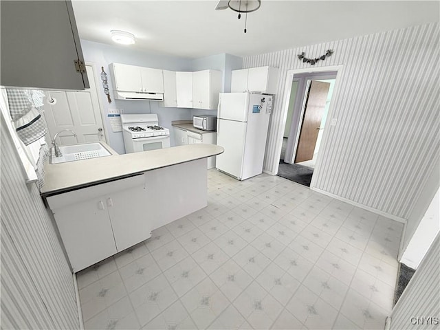 kitchen with white appliances, kitchen peninsula, sink, and white cabinets