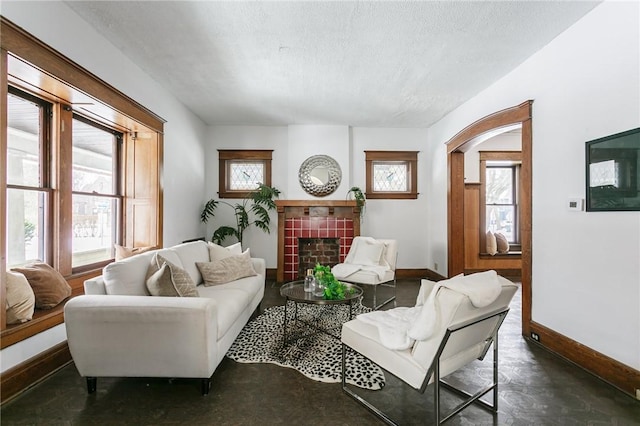 living area featuring a tile fireplace and a textured ceiling