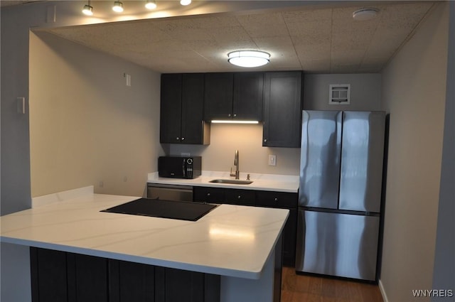 kitchen featuring sink, a paneled ceiling, dark hardwood / wood-style floors, kitchen peninsula, and black appliances