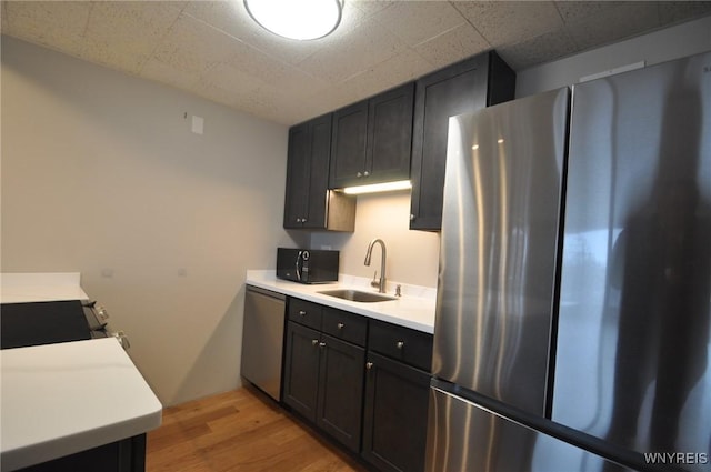 kitchen featuring appliances with stainless steel finishes, sink, and light hardwood / wood-style floors