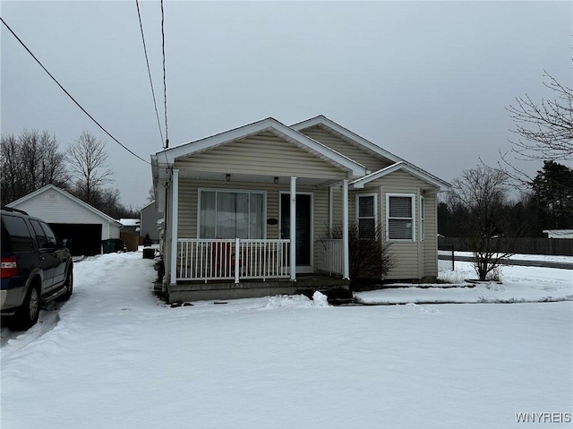 view of front of property with a porch, a garage, and an outdoor structure