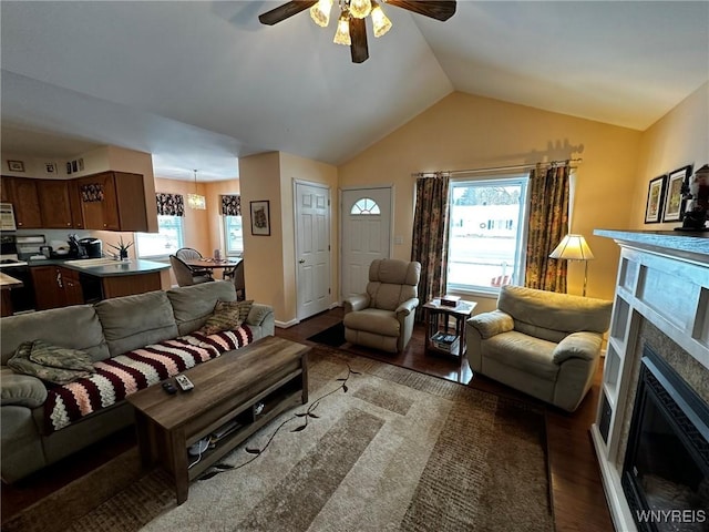 living room with vaulted ceiling, a healthy amount of sunlight, hardwood / wood-style floors, and ceiling fan