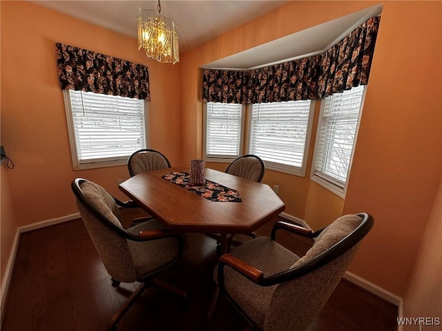 dining space with dark hardwood / wood-style floors and a chandelier