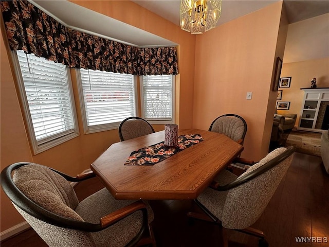 dining room with dark hardwood / wood-style floors and a chandelier