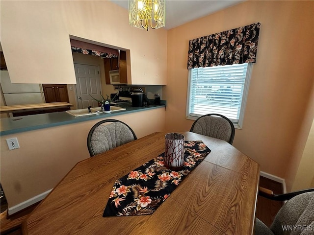 dining space featuring sink and a chandelier