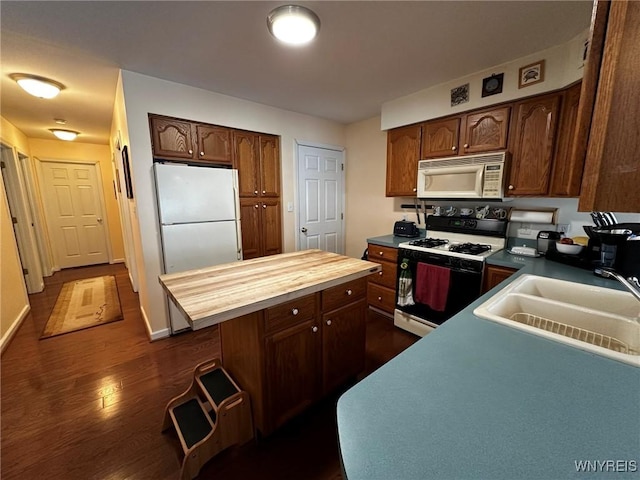 kitchen with sink, white appliances, wooden counters, a kitchen island, and dark hardwood / wood-style flooring