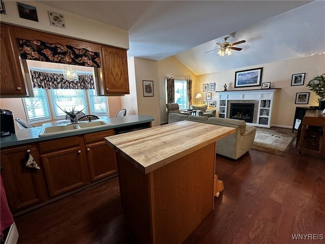 kitchen featuring dark hardwood / wood-style floors, lofted ceiling, sink, a center island, and ceiling fan