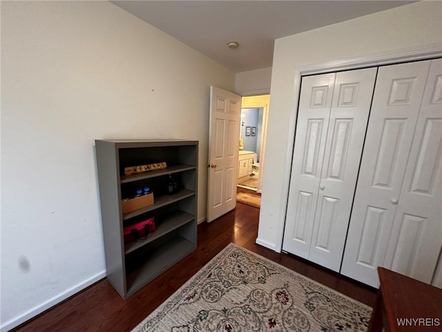 bedroom with dark hardwood / wood-style flooring and a closet