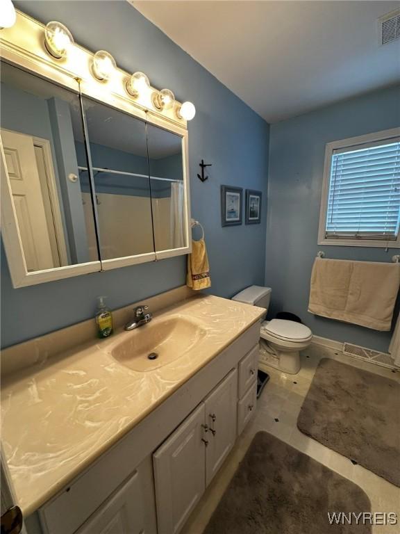 bathroom featuring vanity, toilet, curtained shower, and tile patterned flooring