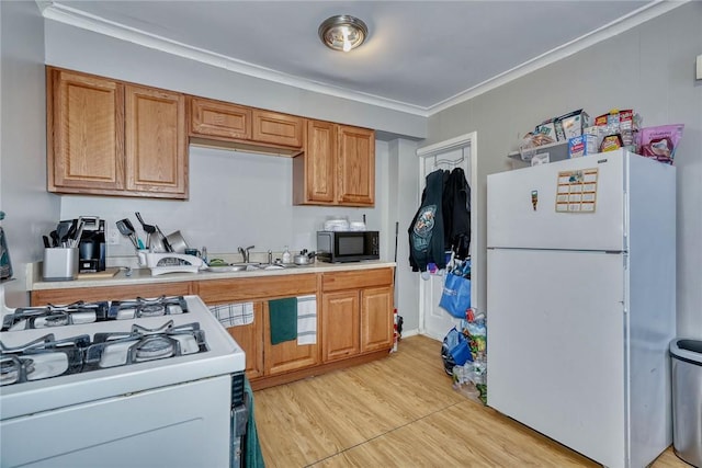 kitchen featuring crown molding, sink, white appliances, and light hardwood / wood-style floors