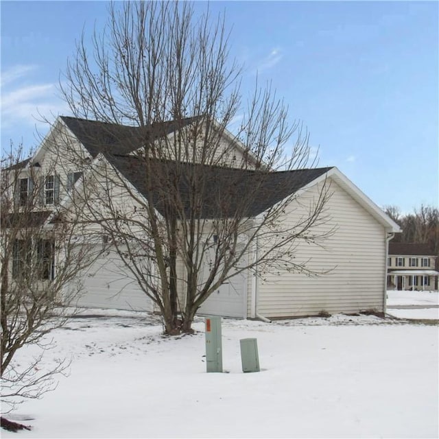 view of snowy exterior with a garage