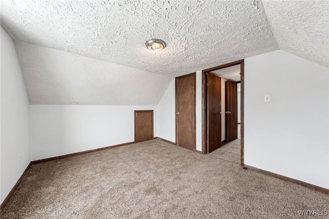 bonus room featuring vaulted ceiling, light carpet, and a textured ceiling