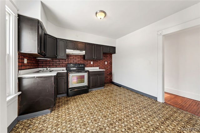 kitchen featuring black range with electric stovetop, sink, and dark brown cabinetry