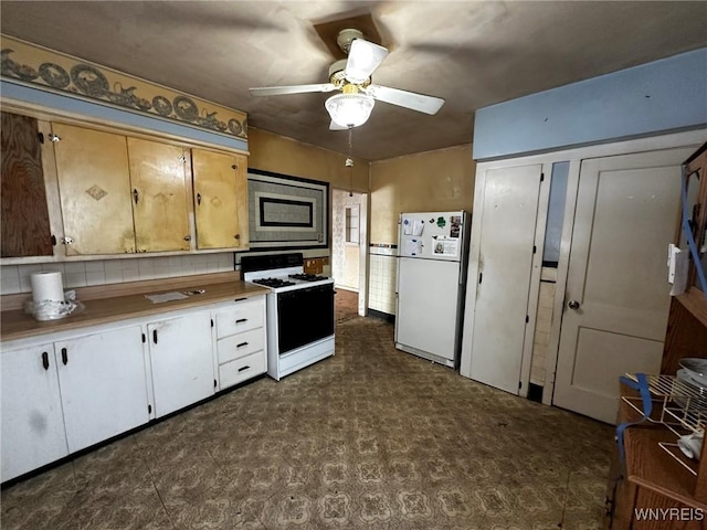 kitchen with range with gas cooktop, white cabinetry, white refrigerator, stainless steel microwave, and ceiling fan