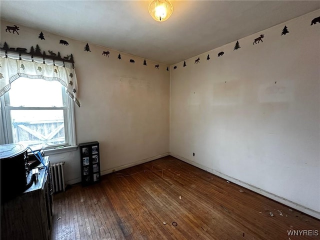 empty room with radiator and dark wood-type flooring