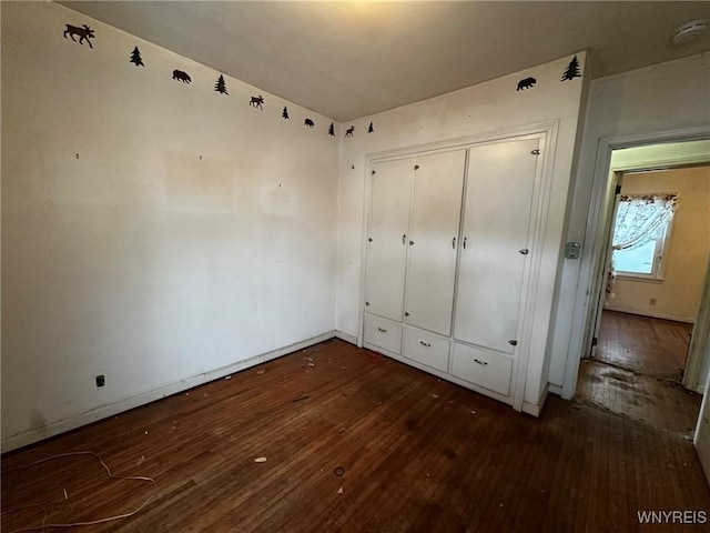 unfurnished bedroom featuring dark hardwood / wood-style flooring and a closet