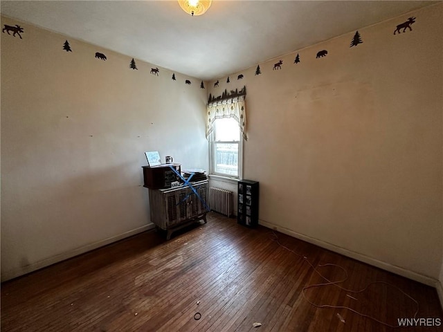 unfurnished room with dark hardwood / wood-style floors and radiator