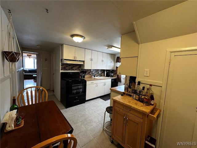 kitchen with black range oven, backsplash, sink, and white cabinets