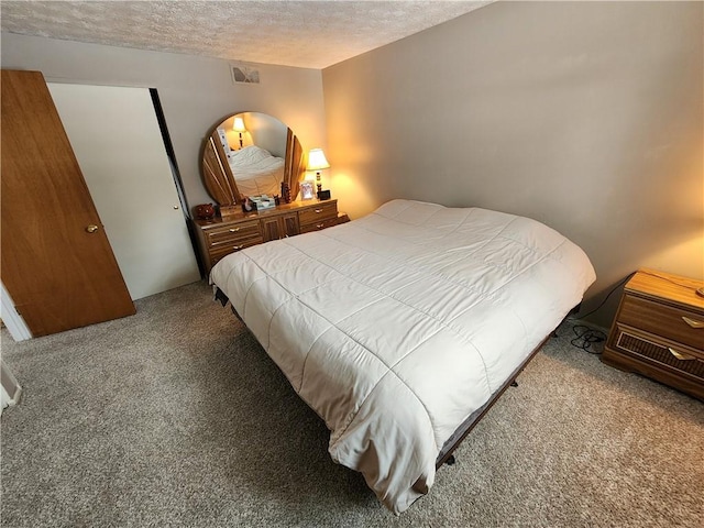 bedroom with light carpet and a textured ceiling