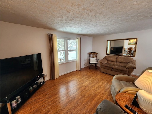 living room featuring a textured ceiling and light wood-type flooring