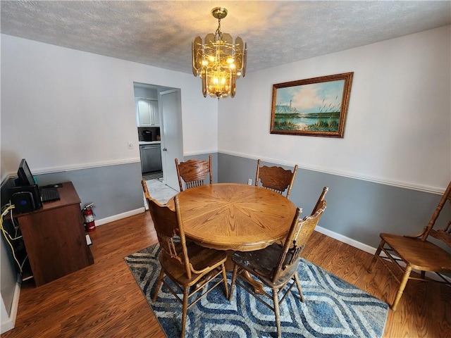 dining space with dark hardwood / wood-style flooring, a textured ceiling, and an inviting chandelier