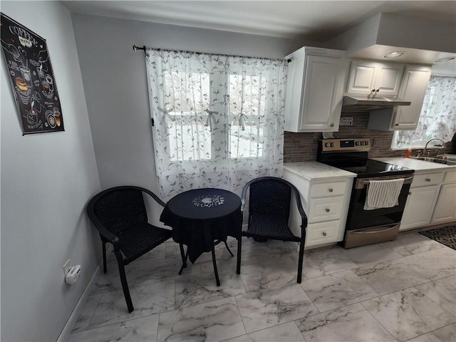 kitchen with tasteful backsplash, sink, electric range, and white cabinets