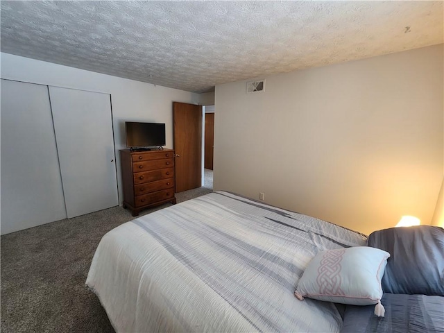 carpeted bedroom featuring a textured ceiling and a closet