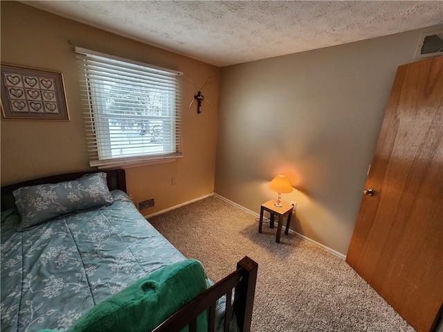 bedroom with carpet floors and a textured ceiling