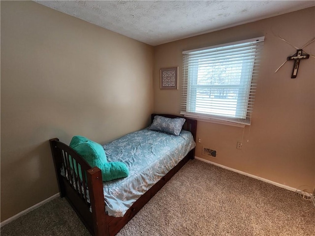 bedroom with carpet floors and a textured ceiling