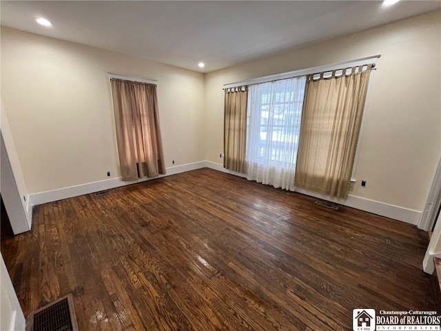 unfurnished room with dark hardwood / wood-style flooring